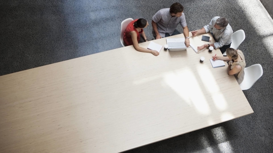 people in a huddle in a meeting room